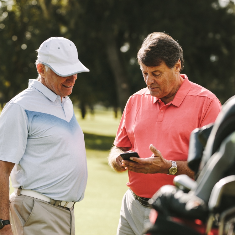 Two golfers looking at their phone