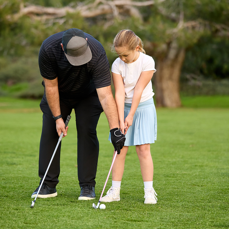 Child getting a golf lesson